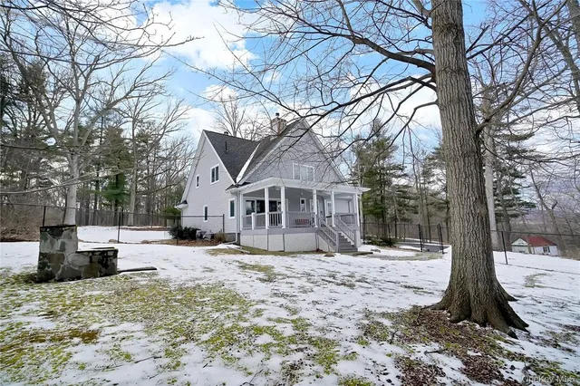 a front view of a house with a yard covered in snow