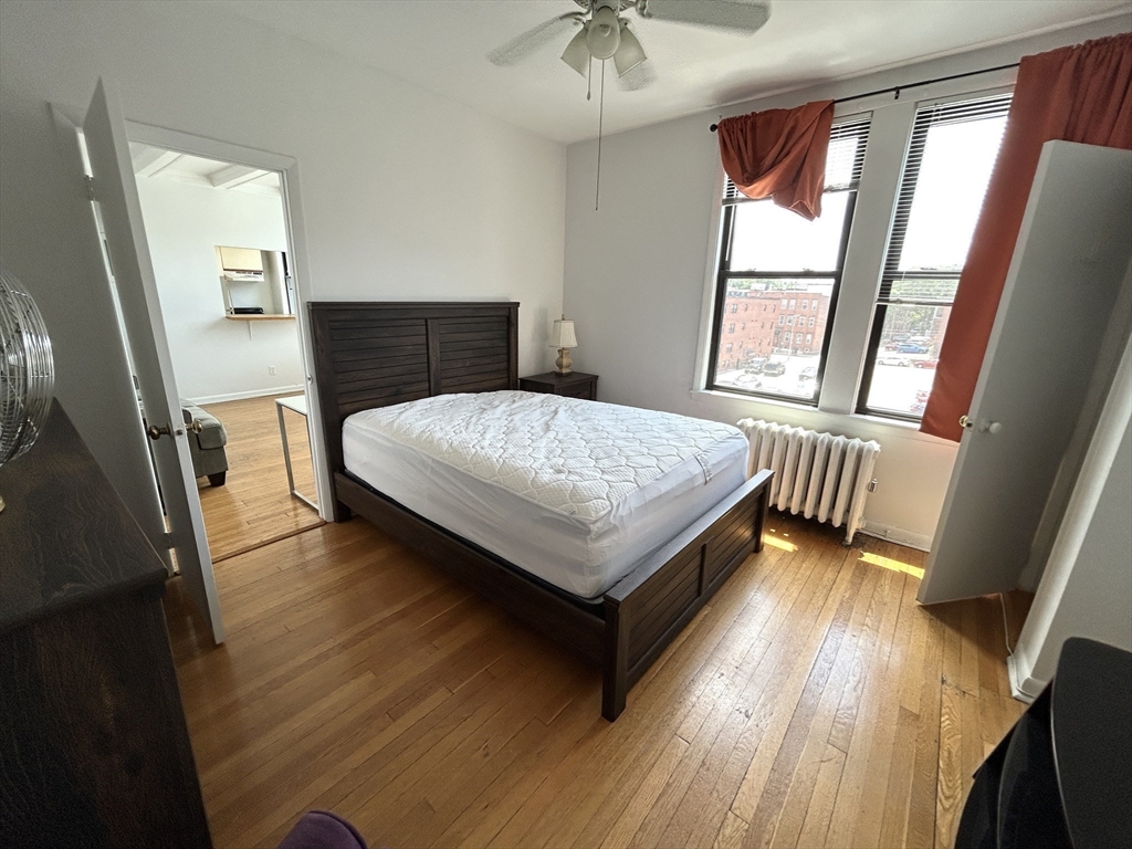 4 Commonwealth Court, Unit 17 Boston, MA 02135 - Photo 11 of 15 a bedroom with a bed and wooden floor