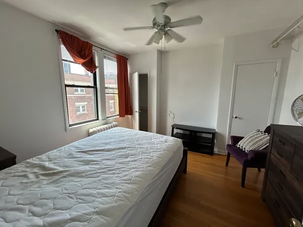 a bedroom with a bed window and dresser