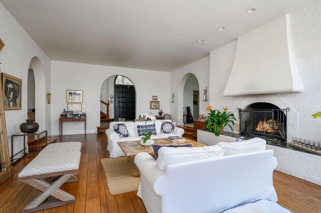 a living room with furniture a fireplace and wooden floor
