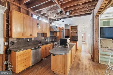 a kitchen with stainless steel appliances granite countertop a sink a stove and refrigerator