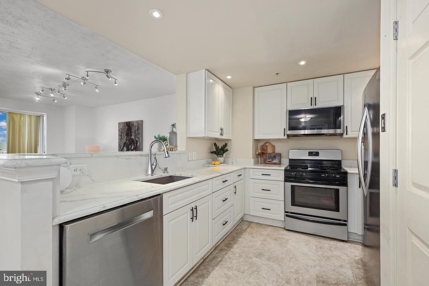 2726 Gallows Road, Unit 1004 Vienna, VA 22180 - Photo 5 of 17 a kitchen with sink a microwave and cabinets
