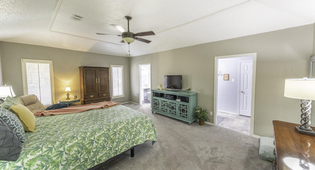 3620 93rd Street Lubbock, TX 79423 - Photo 15 of 33 a bedroom with furniture and a flat screen tv
