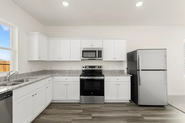 a kitchen with a stove top oven and refrigerator