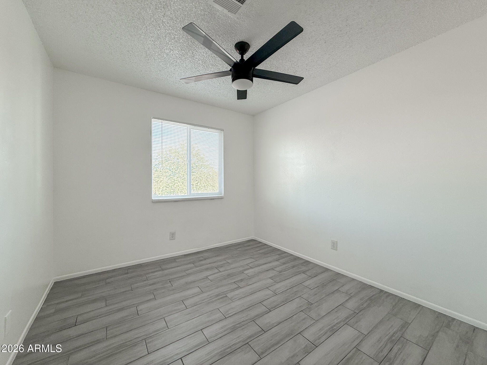 349 North 11th Street, Unit 207 Phoenix, AZ 85006 - Photo 11 of 20 an empty room with wooden floor ceiling fan and window