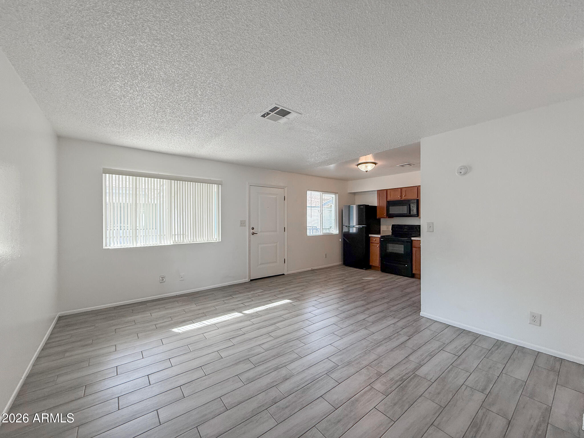 349 North 11th Street, Unit 207 Phoenix, AZ 85006 - Photo 5 of 20 a view of empty room with wooden floor and kitchen