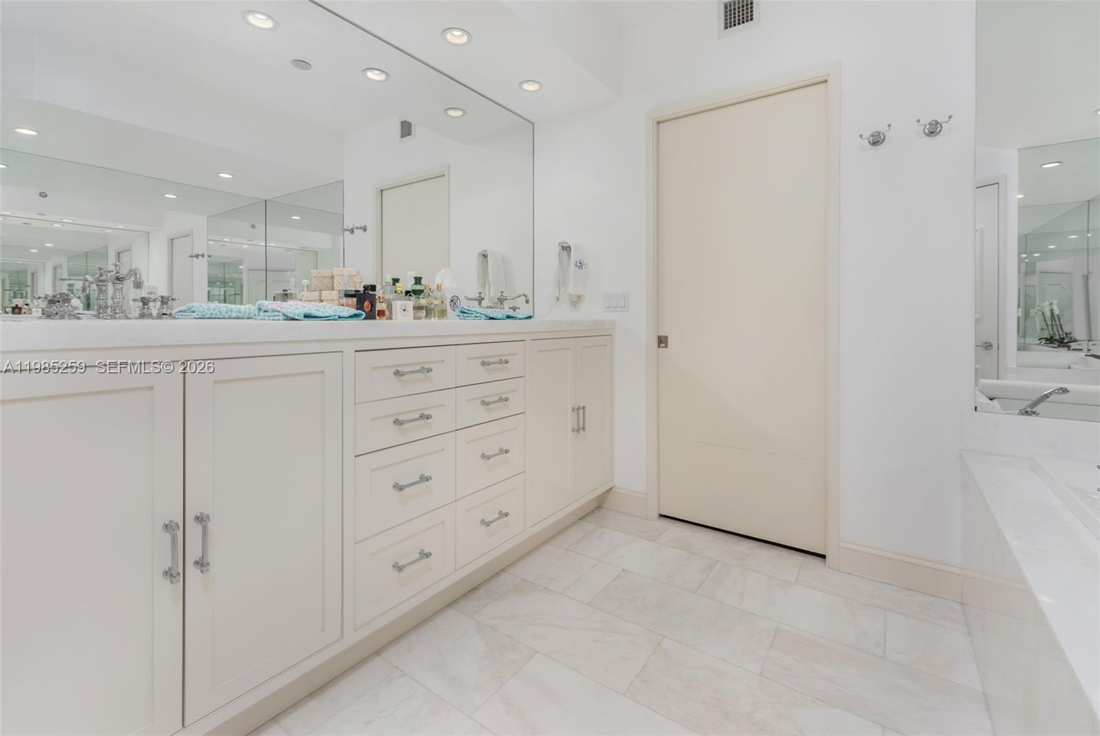 781 Crandon Boulevard, Unit 1603 Key Biscayne, FL 33149 - Photo 14 of 34 a bathroom with a double vanity sink and mirror