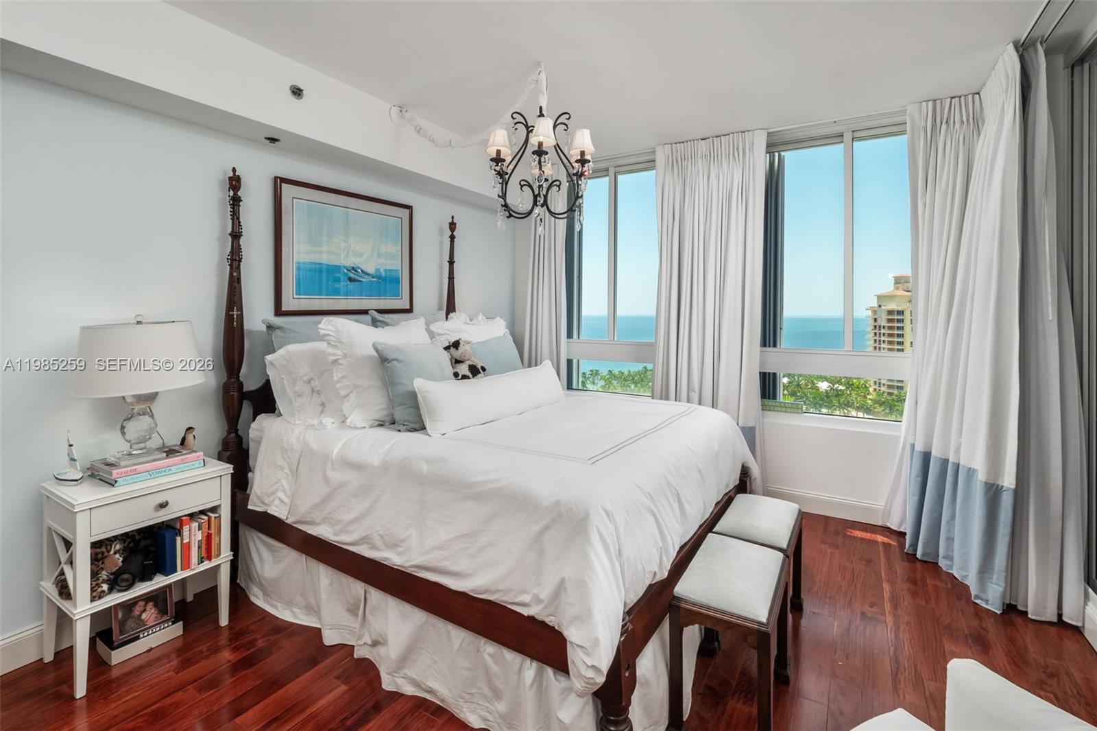 781 Crandon Boulevard, Unit 1603 Key Biscayne, FL 33149 - Photo 15 of 34 a bedroom with a bed and a chandelier