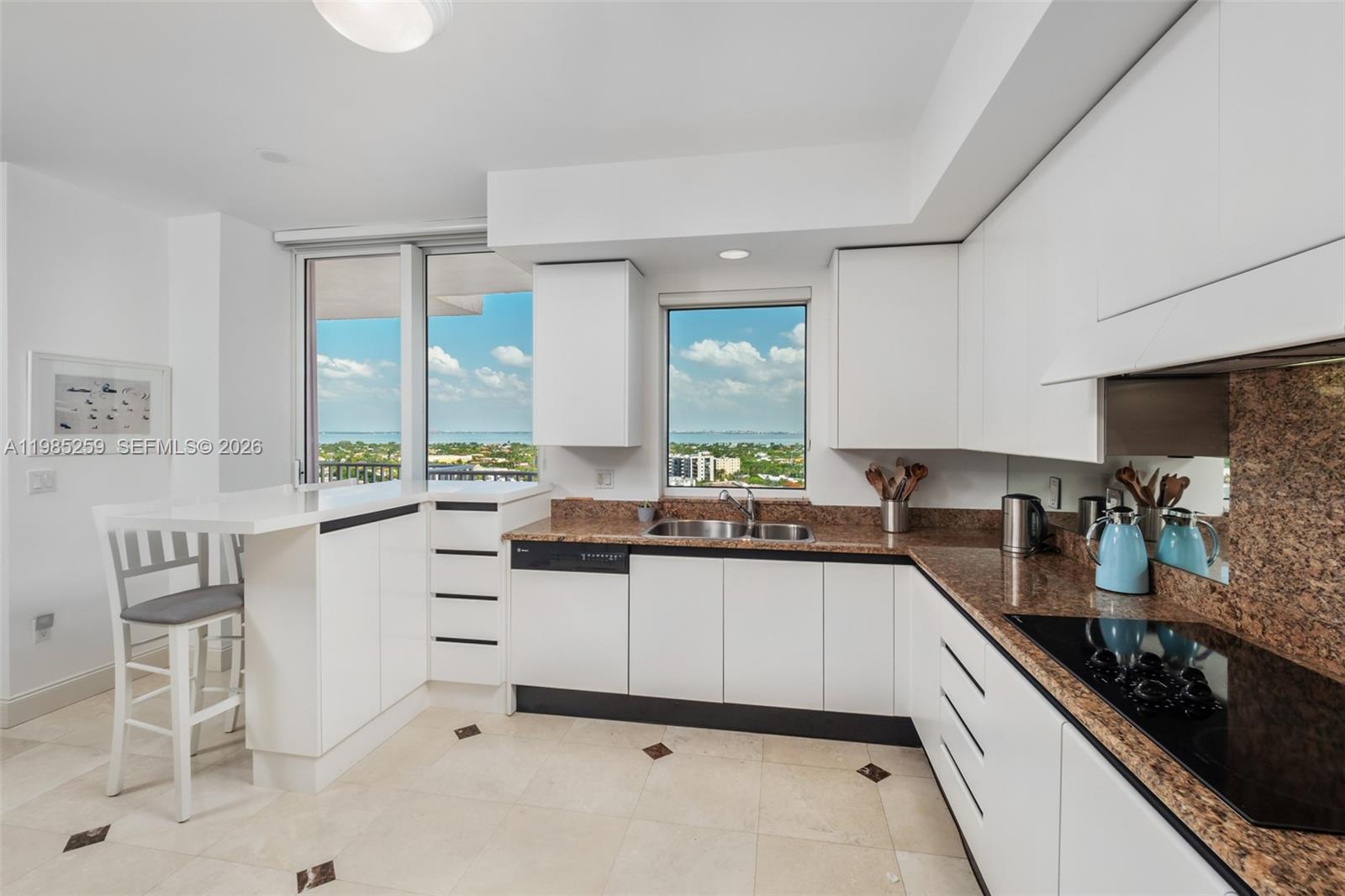 781 Crandon Boulevard, Unit 1603 Key Biscayne, FL 33149 - Photo 7 of 34 a kitchen with white cabinets and appliances