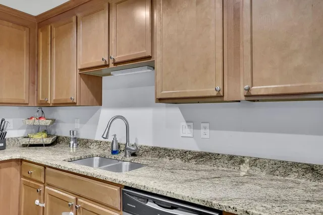 a kitchen with granite countertop stainless steel appliances and refrigerator