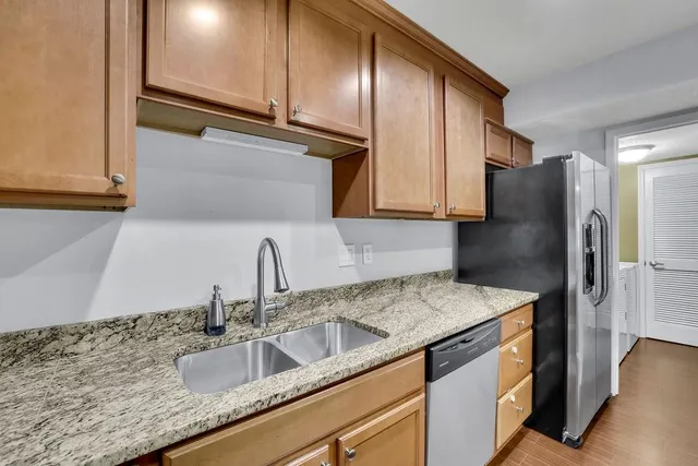 a kitchen with stainless steel appliances granite countertop a sink stove and cabinets