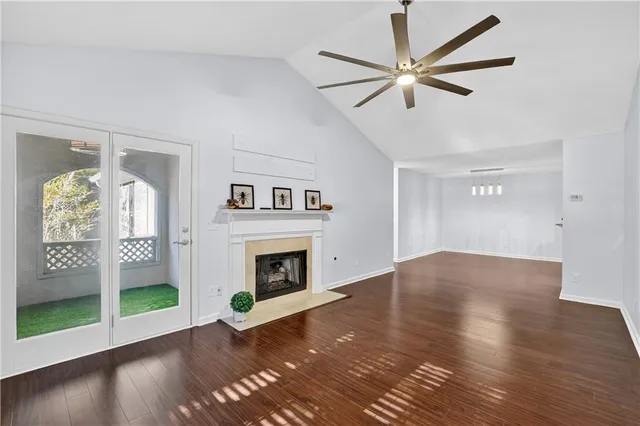 a view of an empty room with wooden floor and a fireplace