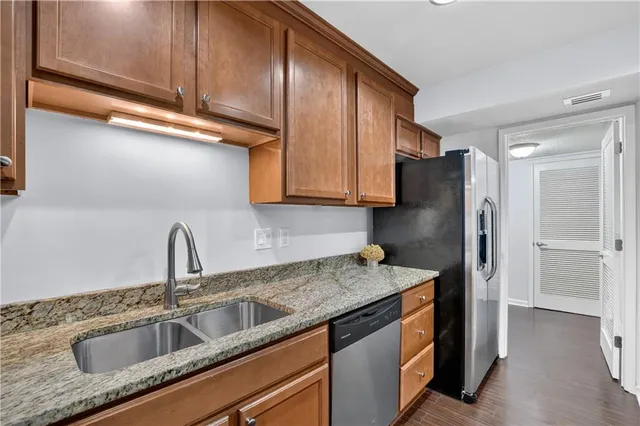 a kitchen with granite countertop wooden cabinets and a stove top oven