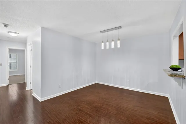 a view of empty room with wooden floor and windows