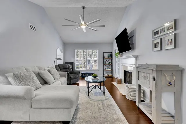 a living room with furniture a fireplace and a flat screen tv