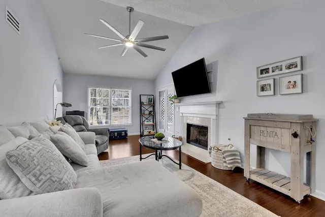 a living room with furniture a fireplace and a flat screen tv