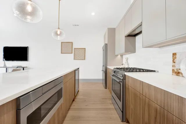 a kitchen with stainless steel appliances a sink stove and cabinets