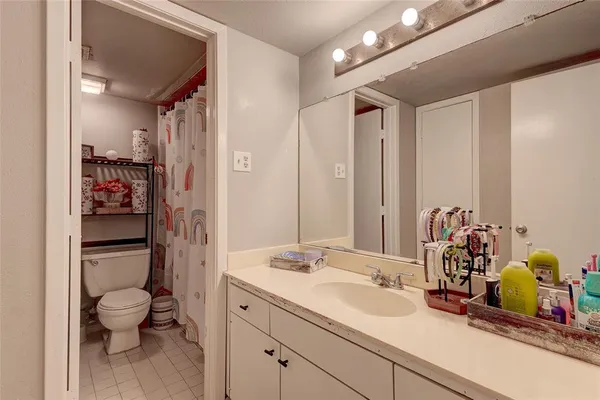 a bathroom with a sink vanity granite and toilet