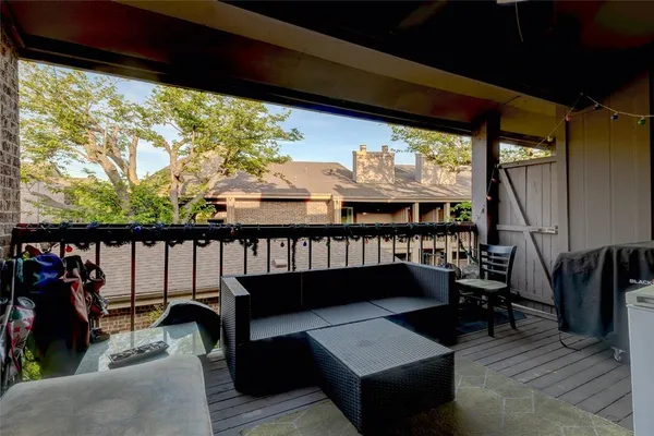 a view of a balcony with chairs and wooden floor