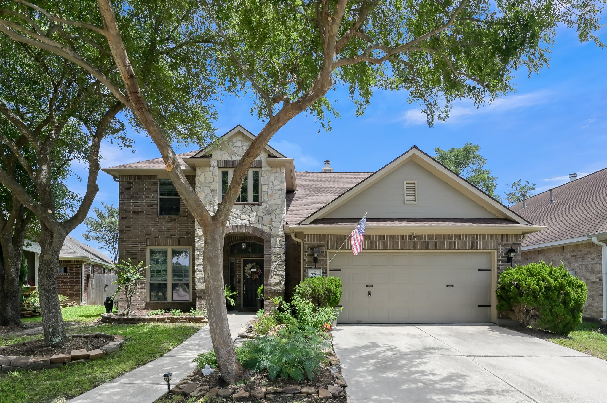 28522 Misty Cliff Lane Spring, TX 77386 - Photo 12 of 12 Beautiful two-story home with striking stone and brick elevation, mature shade trees, and a spacious two-car garage. Well-maintained landscaping and inviting curb appeal create a warm welcome from the moment you arrive.