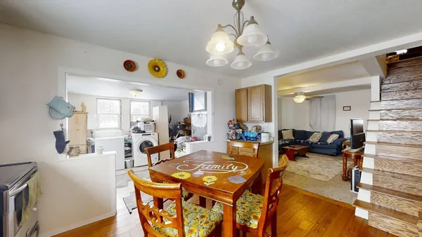 a view of a dining room with furniture a chandelier and wooden floor