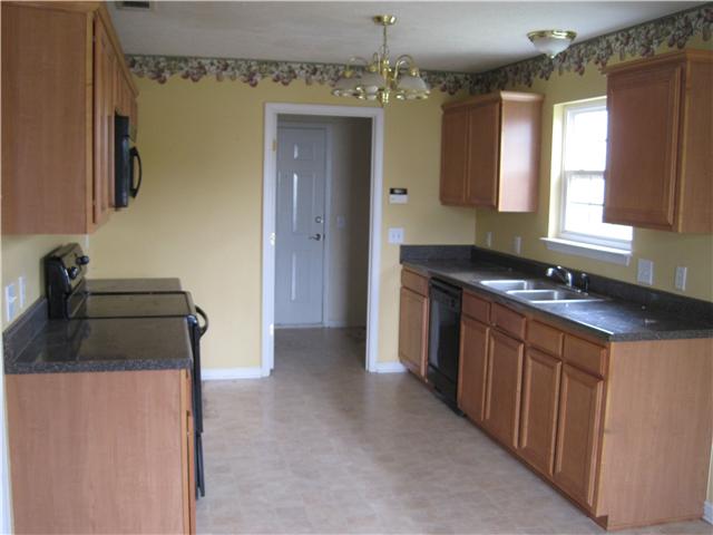 1954 Portway Road Spring Hill, TN 37174 - Photo 7 of 16 Another kitchen view shows cabinets on both walls and door leading to the laundry room and garage.