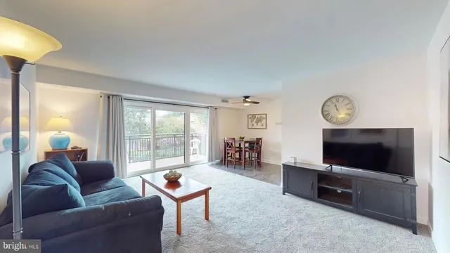 a living room with furniture a flat screen tv and a window