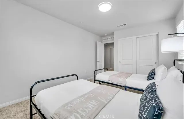 a bedroom with two beds and a lamp