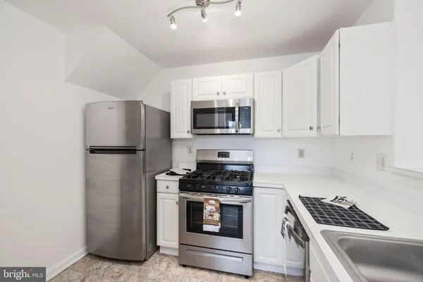 a kitchen with stainless steel appliances a refrigerator stove and microwave