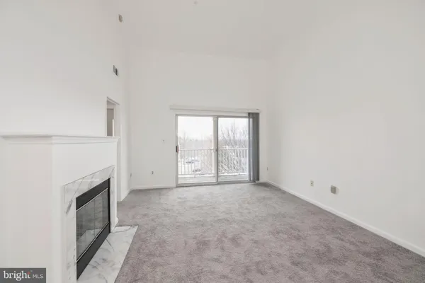 a view of an empty room with a fireplace and a window