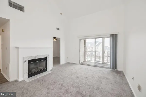 an empty room with windows and fireplace