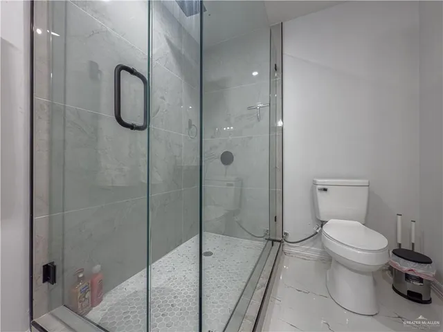 a bedroom with a large bed and a wooden floor