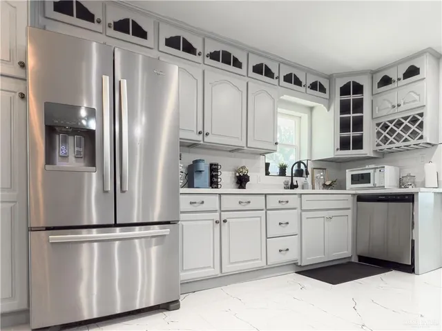 a kitchen with stainless steel appliances a refrigerator sink and cabinets