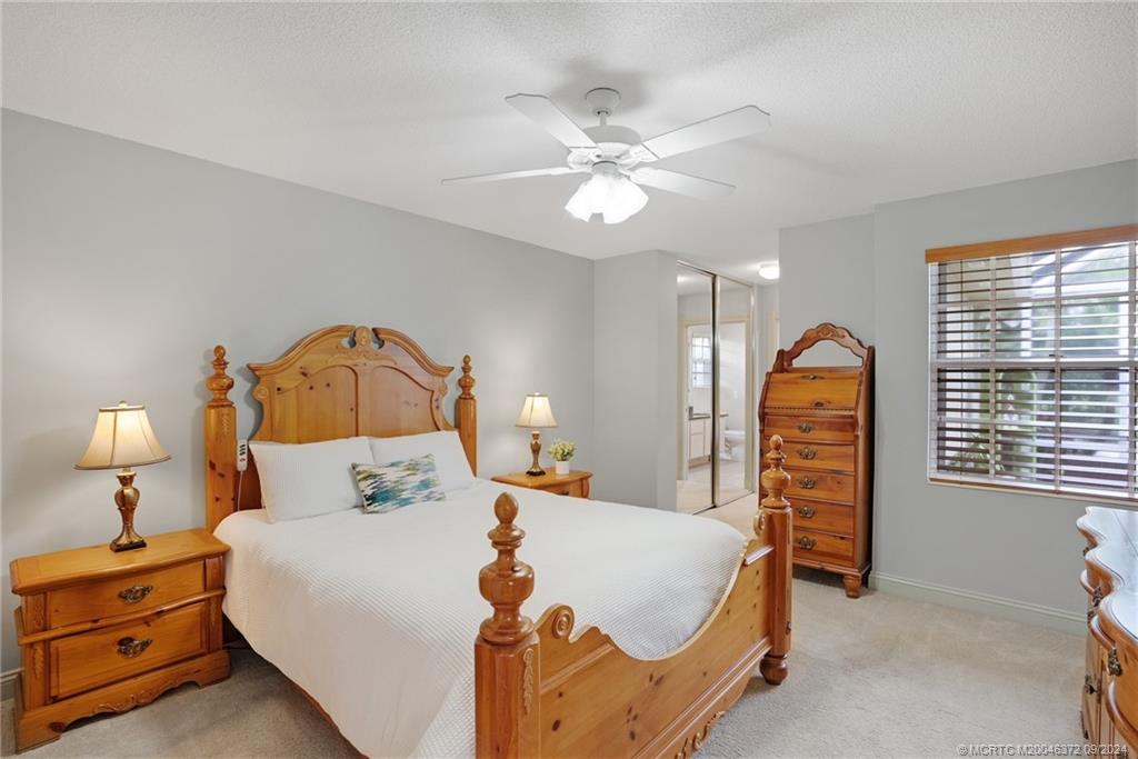 1663 Southwest Springfield Court Palm City, FL 34990 - Photo 11 of 27 a bedroom with a bed and a chandelier