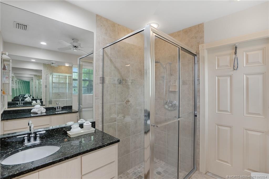 1663 Southwest Springfield Court Palm City, FL 34990 - Photo 12 of 27 a bathroom with double vanity and a shower