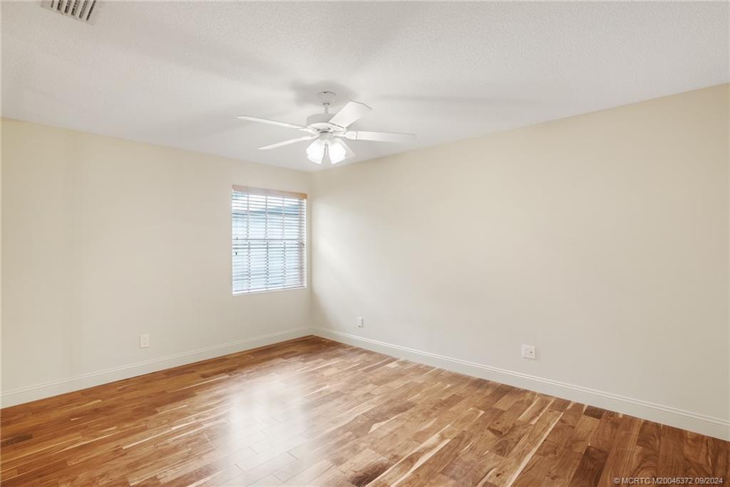 1663 Southwest Springfield Court Palm City, FL 34990 - Photo 15 of 27 an empty room with wooden floor and window