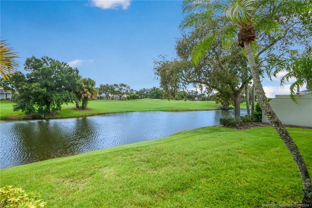 1663 Southwest Springfield Court Palm City, FL 34990 - Photo 19 of 27 a view of a lake with a house in the background
