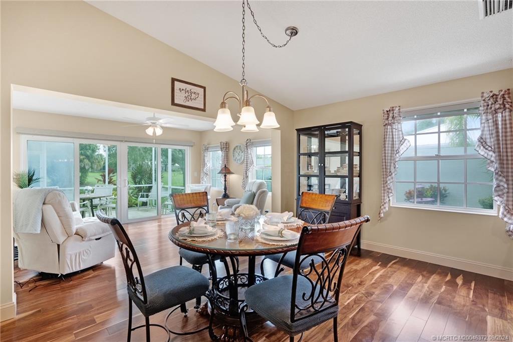 1663 Southwest Springfield Court Palm City, FL 34990 - Photo 6 of 27 a dining room with furniture a chandelier and wooden floor