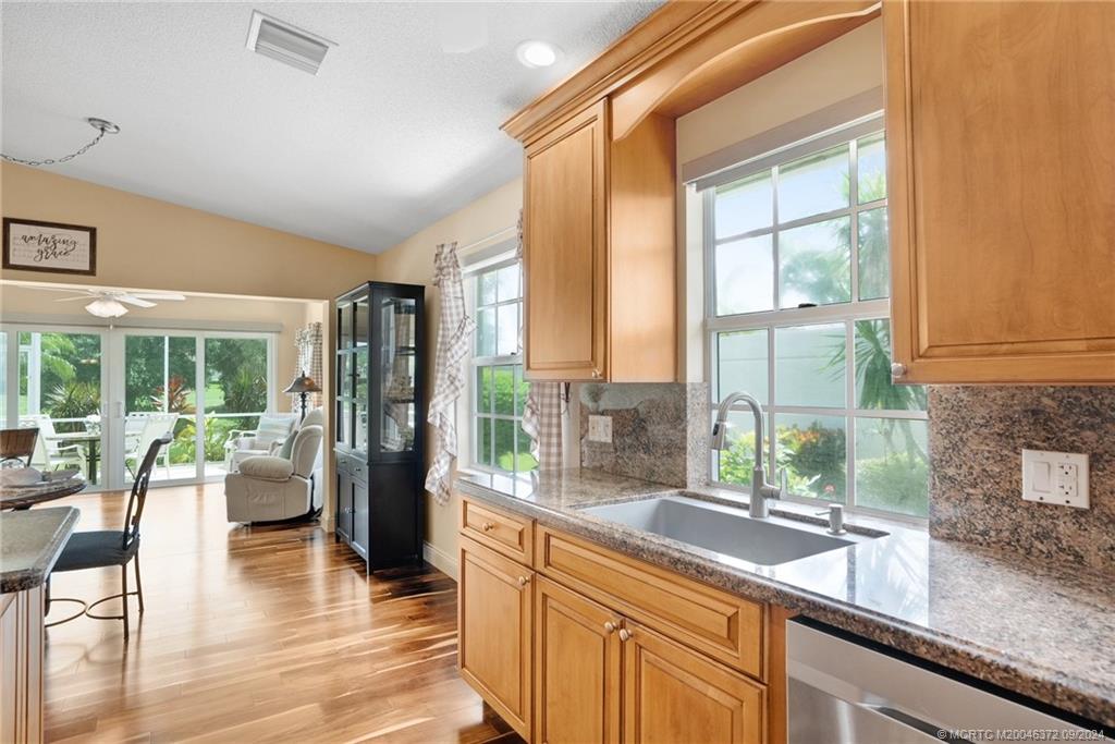 1663 Southwest Springfield Court Palm City, FL 34990 - Photo 10 of 27 a view of a kitchen with kitchen island granite countertop a large window and a counter space