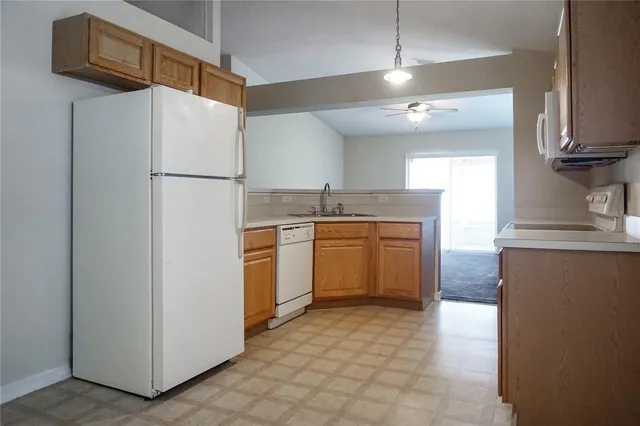 a kitchen with a sink refrigerator and cabinets