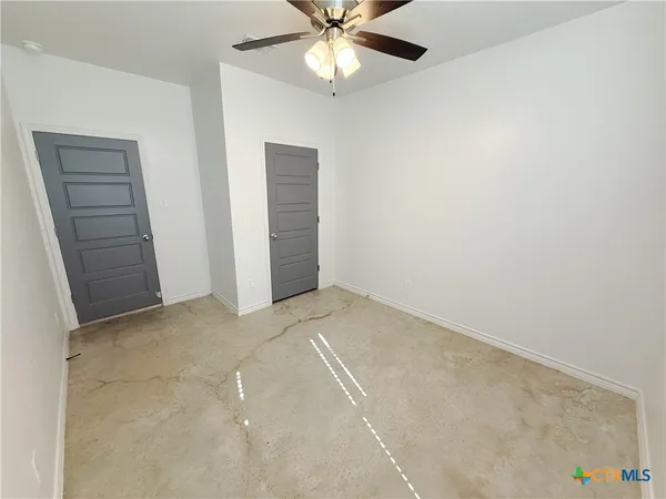 an empty room with closet and fan