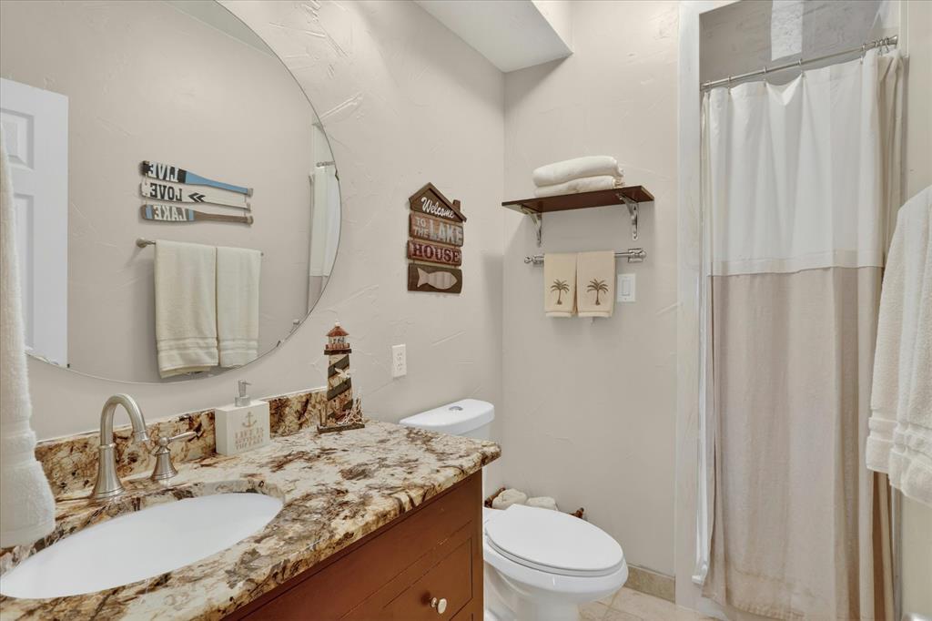8877 Random Road Fort Worth, TX 76179 - Photo 20 of 40 a bathroom with a granite countertop sink toilet and shower
