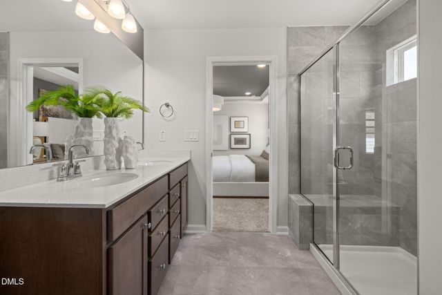 a spacious bathroom with a shower sink and mirror