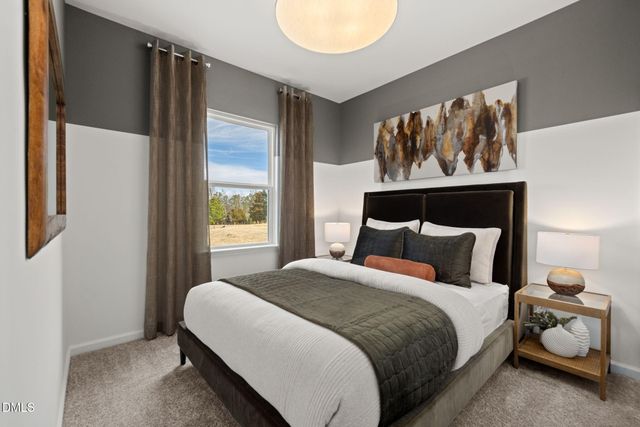 a bedroom with a bed and painting on the wall