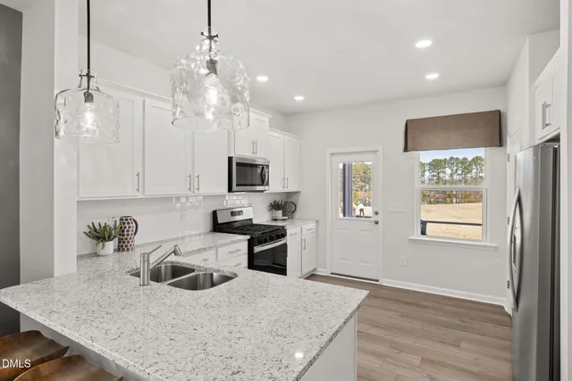 a kitchen with kitchen island white cabinets and refrigerator