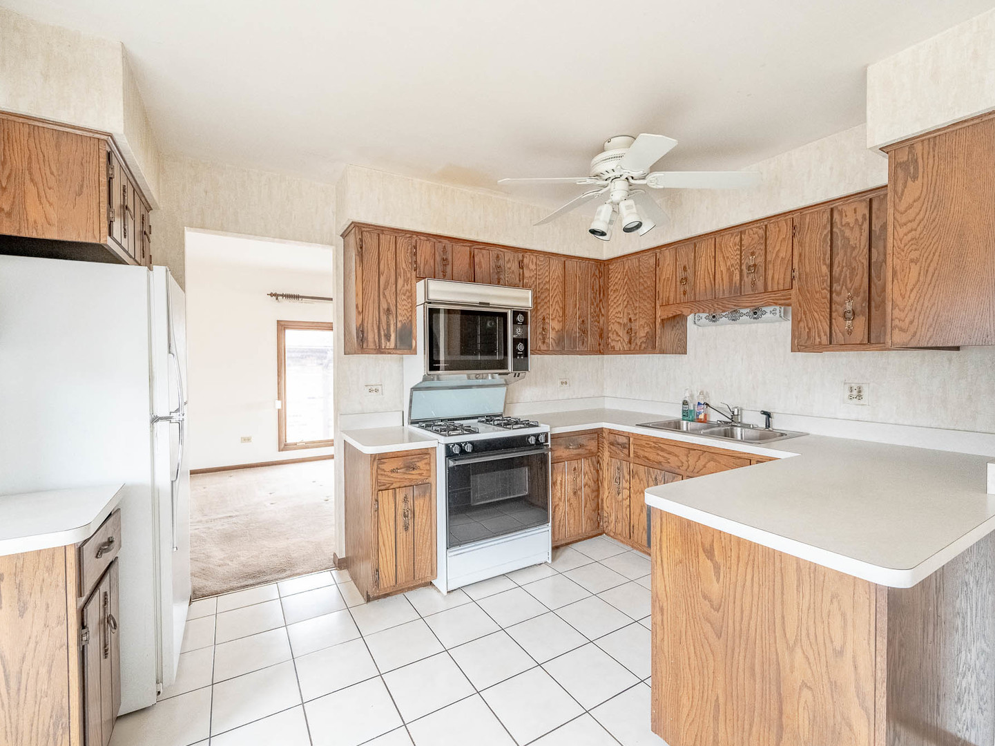 18549 Old Farm Road Lansing, IL 60438 - Photo 4 of 16 a kitchen with a stove a sink and a refrigerator