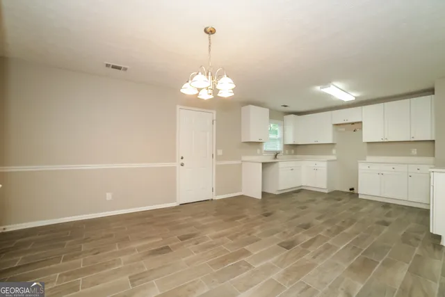 a view of a kitchen with a sink cabinets and wooden floor