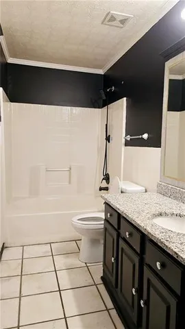 a bathroom with a granite countertop sink a toilet and bathtub