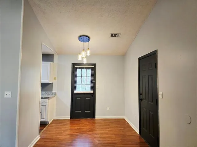 a view of empty room with wooden floor and cabinets