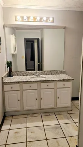 a spacious bathroom with a granite countertop sink and a mirror